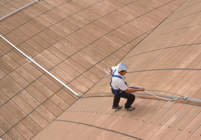 Trabajador sobre un tejado asegurado con una línea de vida inclinada u oblicua