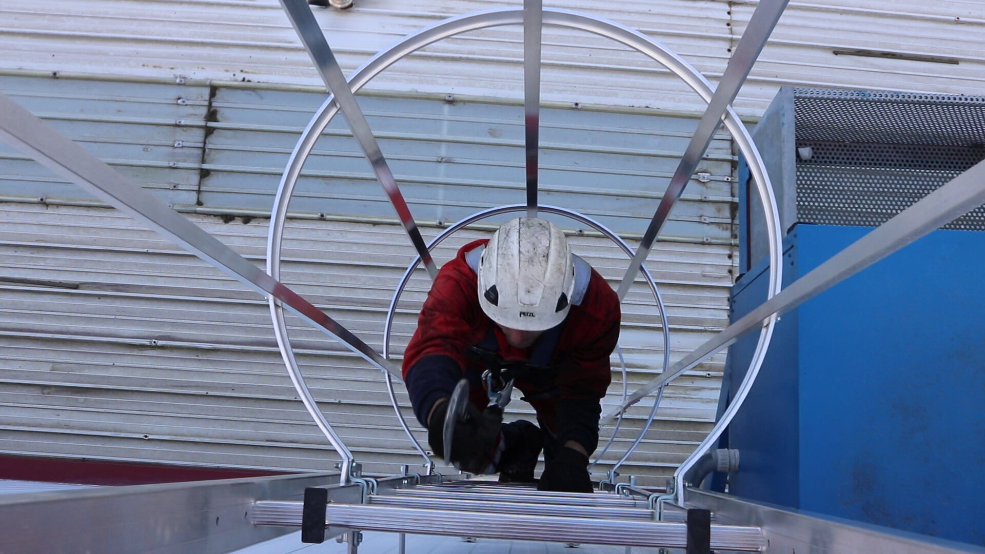 Trabajador subiendo por una escalera con quitamiedo