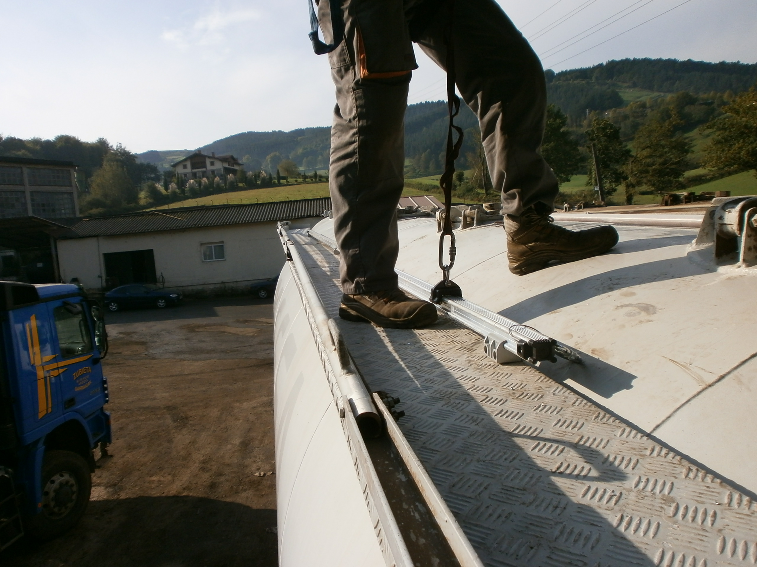Trabajador sobre un tejado asegurado con un raíl horizontal