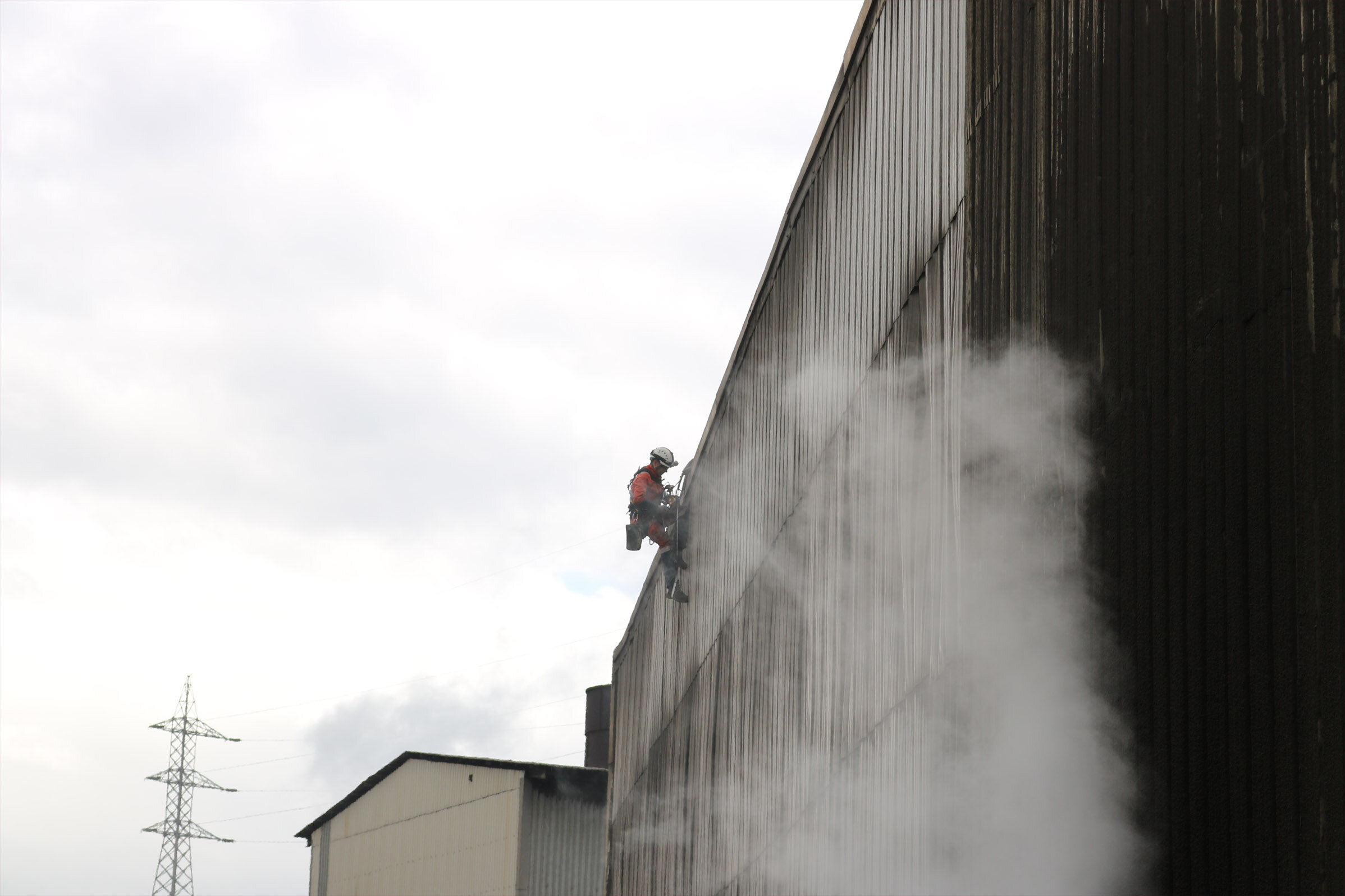 Trabajador suspendido por la fachada de un edificio