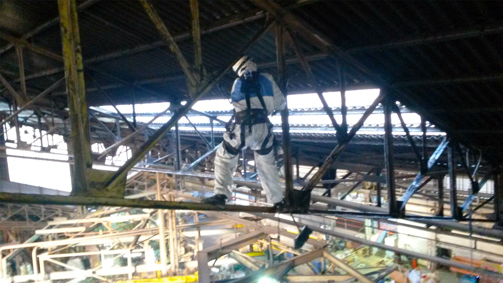 Operario trabajando sobre bigas con los sistemas de protección adecuados