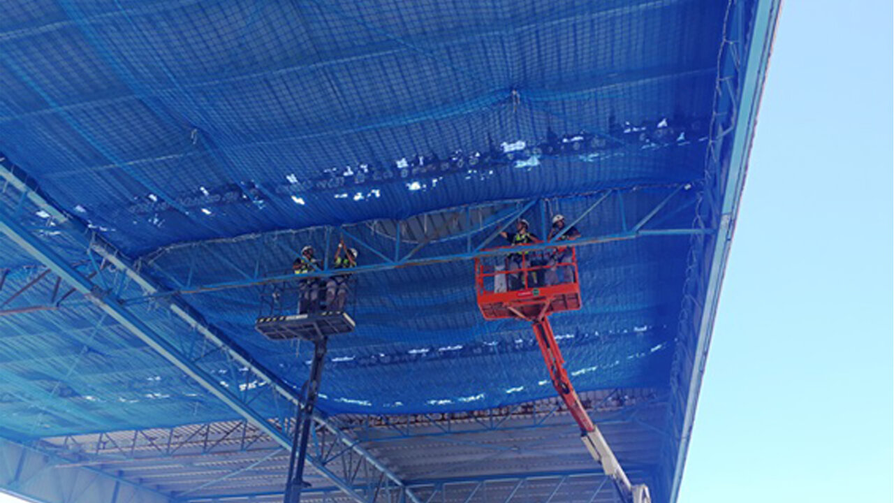 Redes anticaídas internas Profesionales trabajando en la instalación y retirada de redes anticaídas